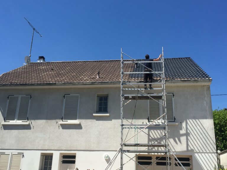Couvreur sur échafaudage roulant en bas de toiture